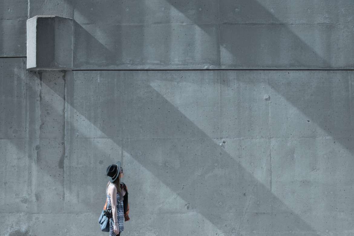 girl looking at concrete wall